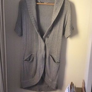 Athleta short sleeved sweater vest. Zip pockets, high/low hem, snap buttons